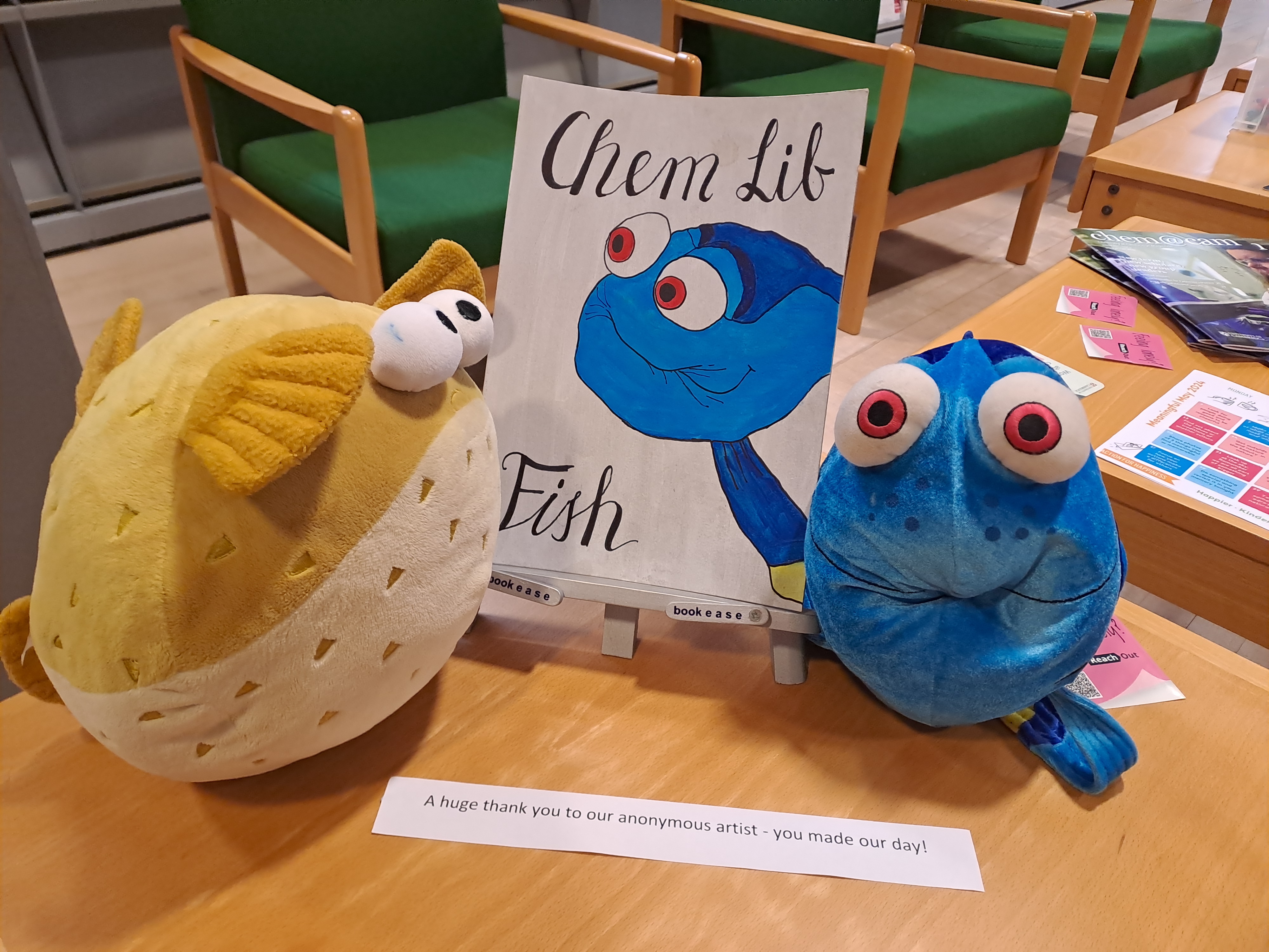 Two stuffed toy fish and a painting of one of the fish